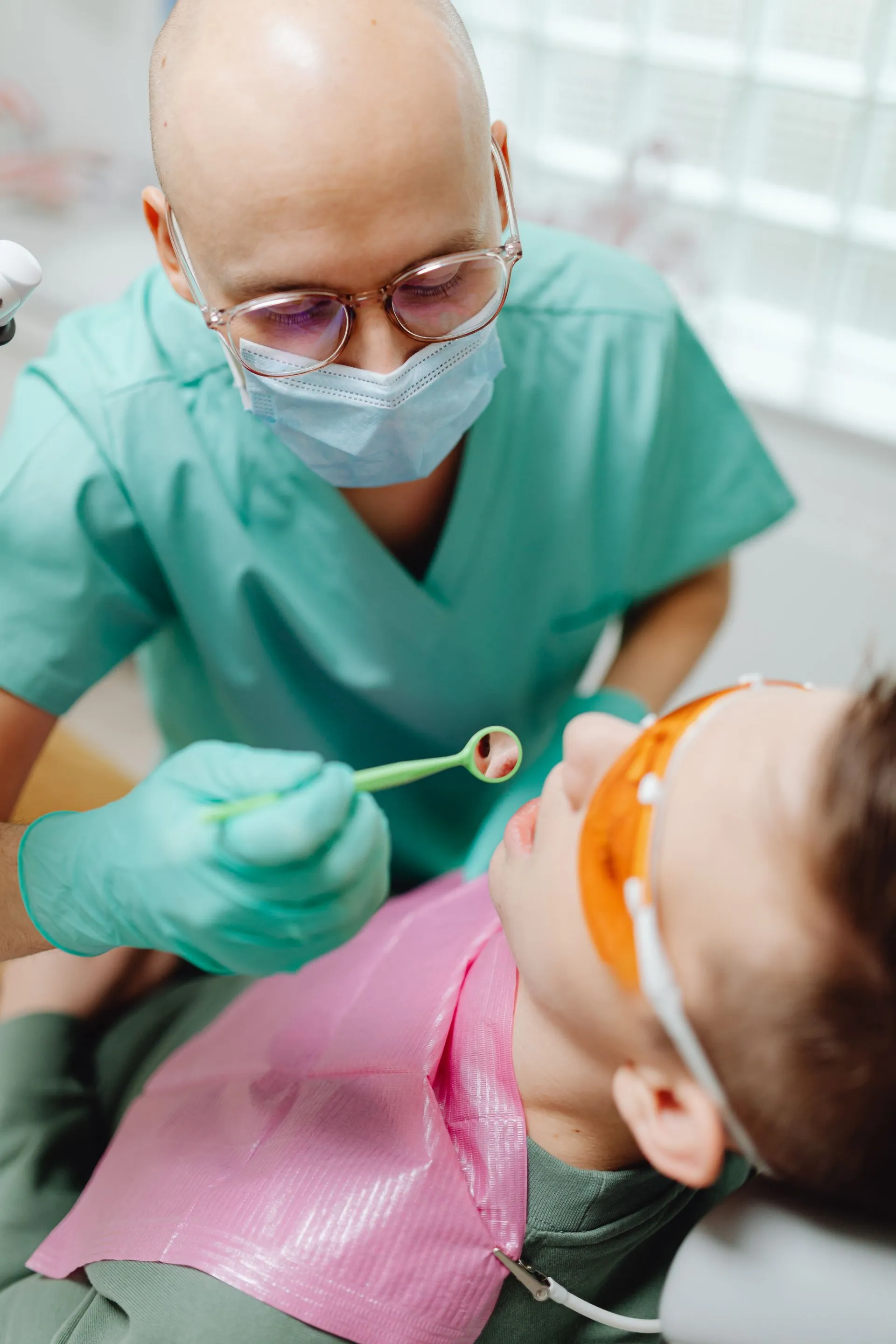 Dentista examinando la dentadura de un niño con un espejo dental